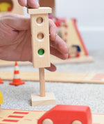 The wooden mini traffic light toy by Beck-Holzspielzeug, being switched to a green light for small world city play. 