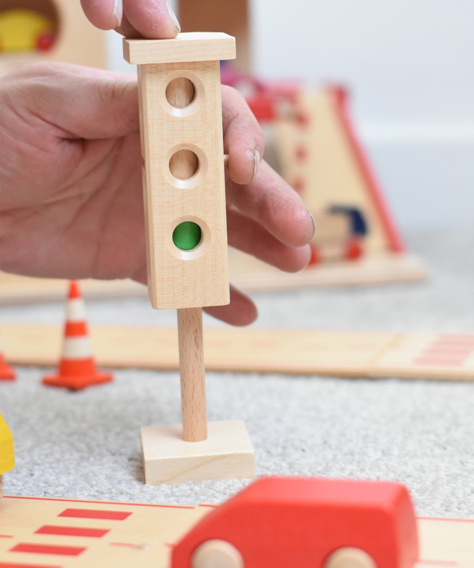 The wooden mini traffic light toy by Beck-Holzspielzeug, being switched to a green light for small world city play. 