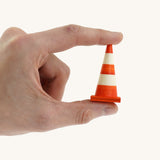 An adult hand holding the Beck mini wooden traffic cone available at Babipur showing scale