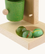 A close up of all 3 marbles in the bottom hole on the base of the Beck coloured roller cup marble run available at Babipur 