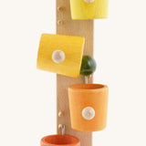 A close up of the Beck coloured roller cup marble run available at Babipur showing the marble falling out of the tilting cup