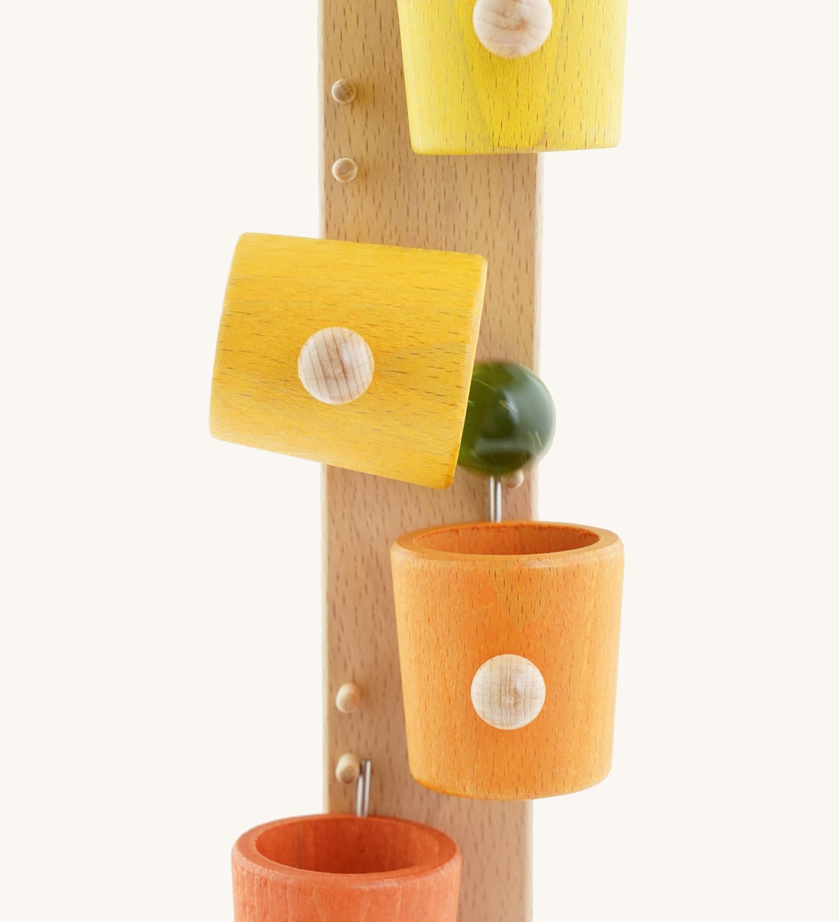 A close up of the Beck coloured roller cup marble run available at Babipur showing the marble falling out of the tilting cup