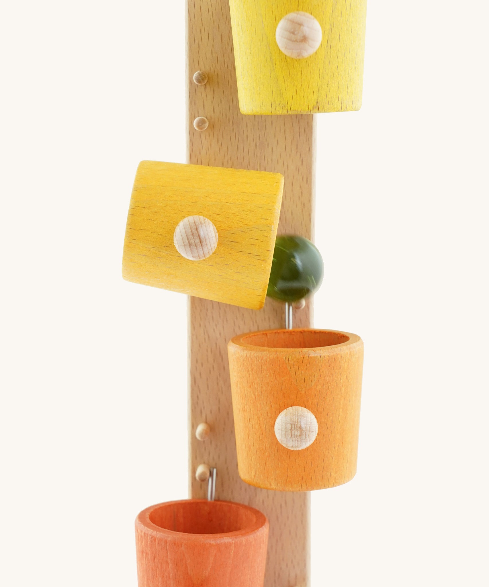 A close up of the Beck coloured roller cup marble run available at Babipur showing the marble falling out of the tilting cup
