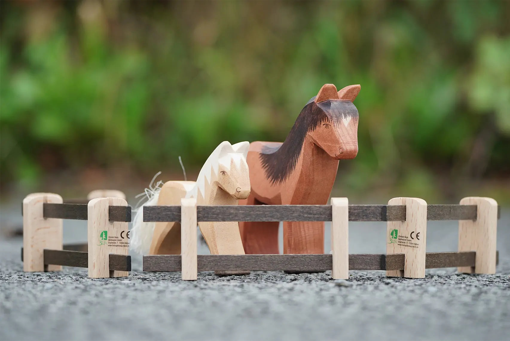 Beck Holzspielzeug wooden toy fence pieces set up as a small-world play pen with Ostheimer wooden horse figures.