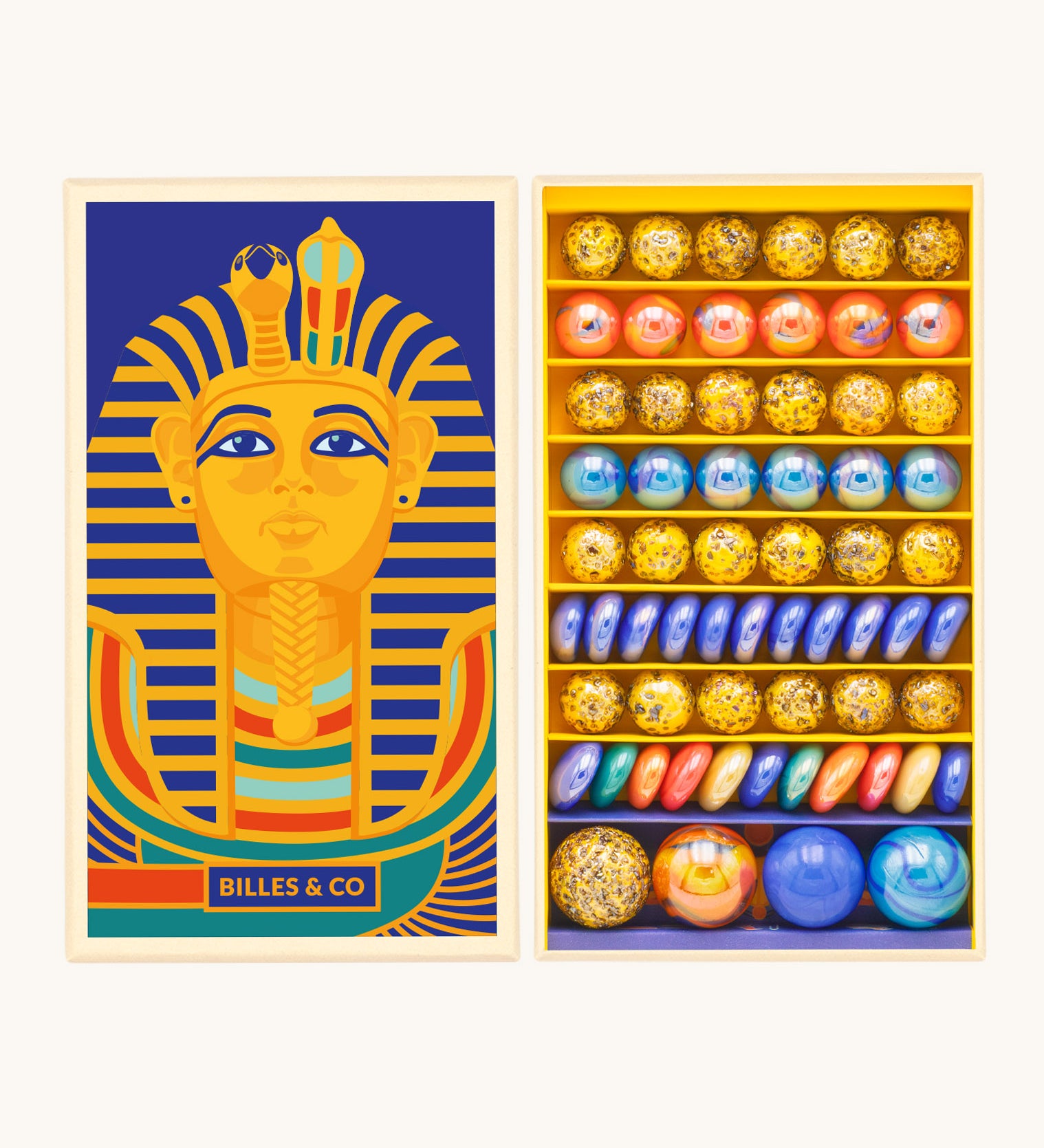 Billes & Co Toutankhamon marble set available at Babipur. A box of 62 marbles and pebbles in Pharaoh inspired colours. Set comes in a cardboard box with a Pharaoh on the front.