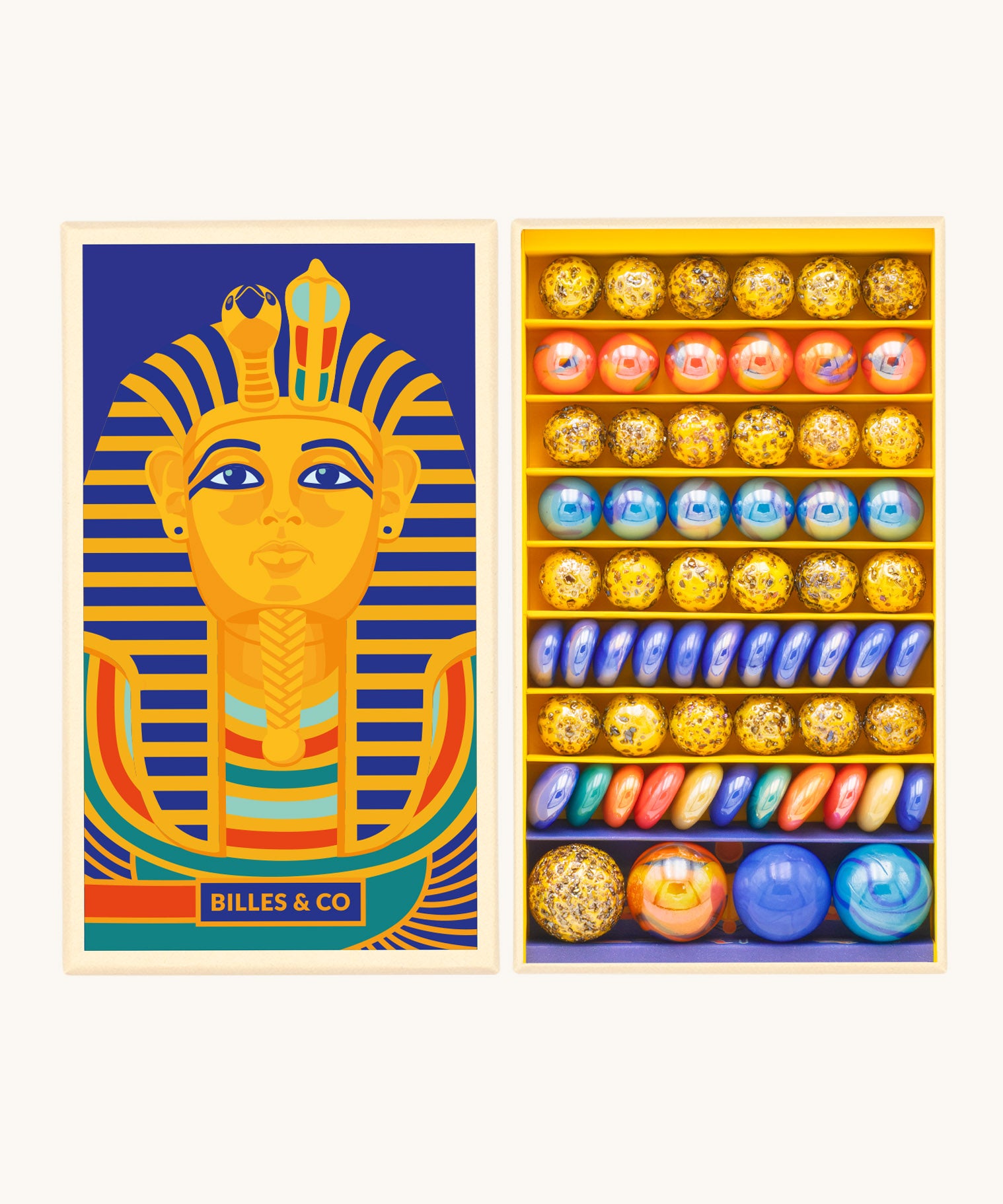 Billes & Co Toutankhamon marble set available at Babipur. A box of 62 marbles and pebbles in Pharaoh inspired colours. Set comes in a cardboard box with a Pharaoh on the front.