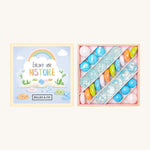 Billes & Co Encore Une Histoire Marbles Box - 29 Pack. A selection of round and flat marbles in pink,blue, orange, green. With clear and frosted light blue marbles
