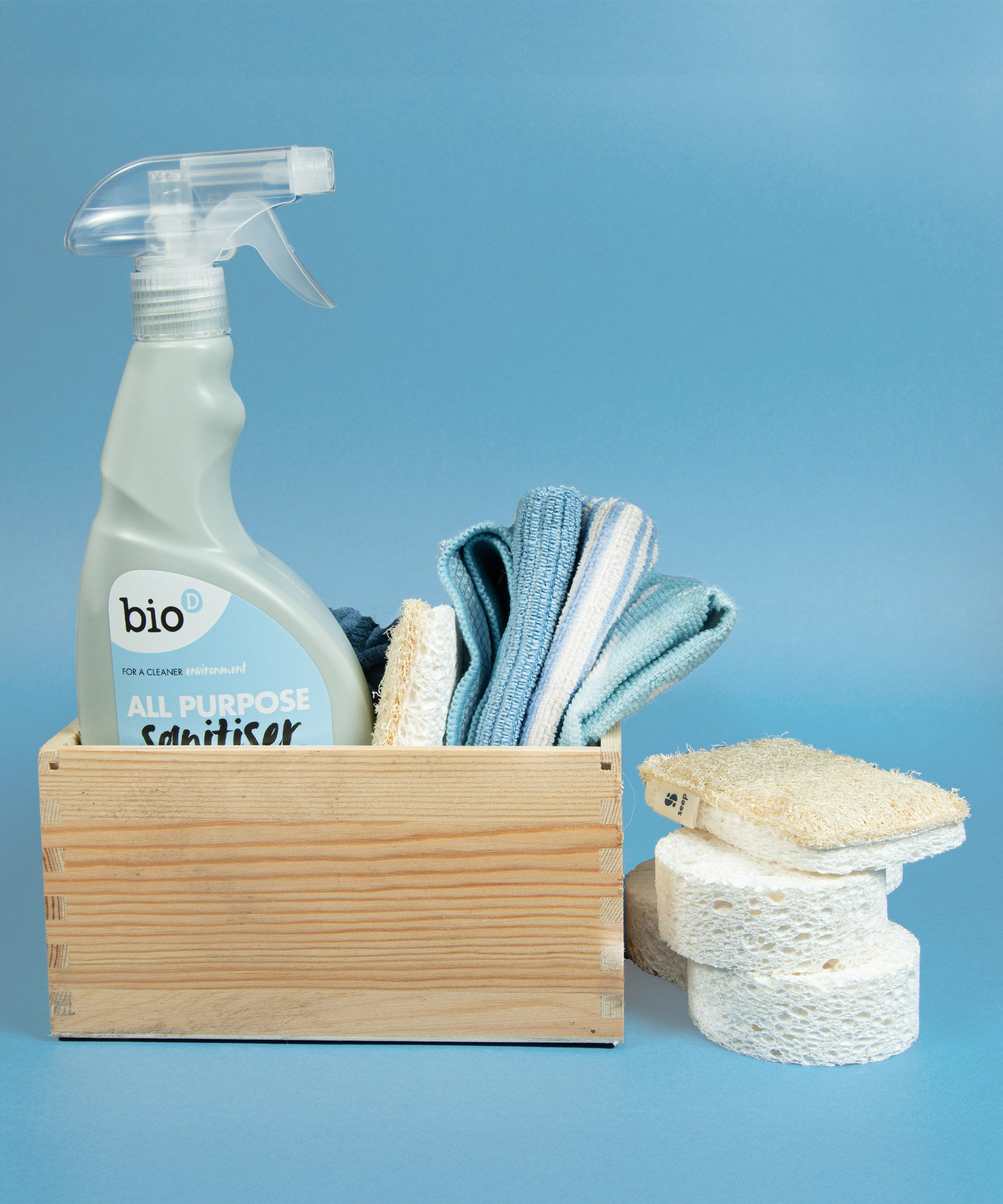 Bio-d 500ml all purpose sanitiser spray in fragrance free sitting inside a wooden caddy with other cleaning products. This sanitiser spray is available at Babipur