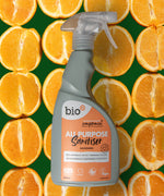 Bio-d 500ml all purpose sanitiser spray in mandarin laid on slicer of mandarin. This sanitiser spray is available at Babipur.