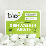 A pile of Bio-D dishwasher tablets in the water soluble film in front of it's packaging. These dishwasher tablets are available at Babipur.