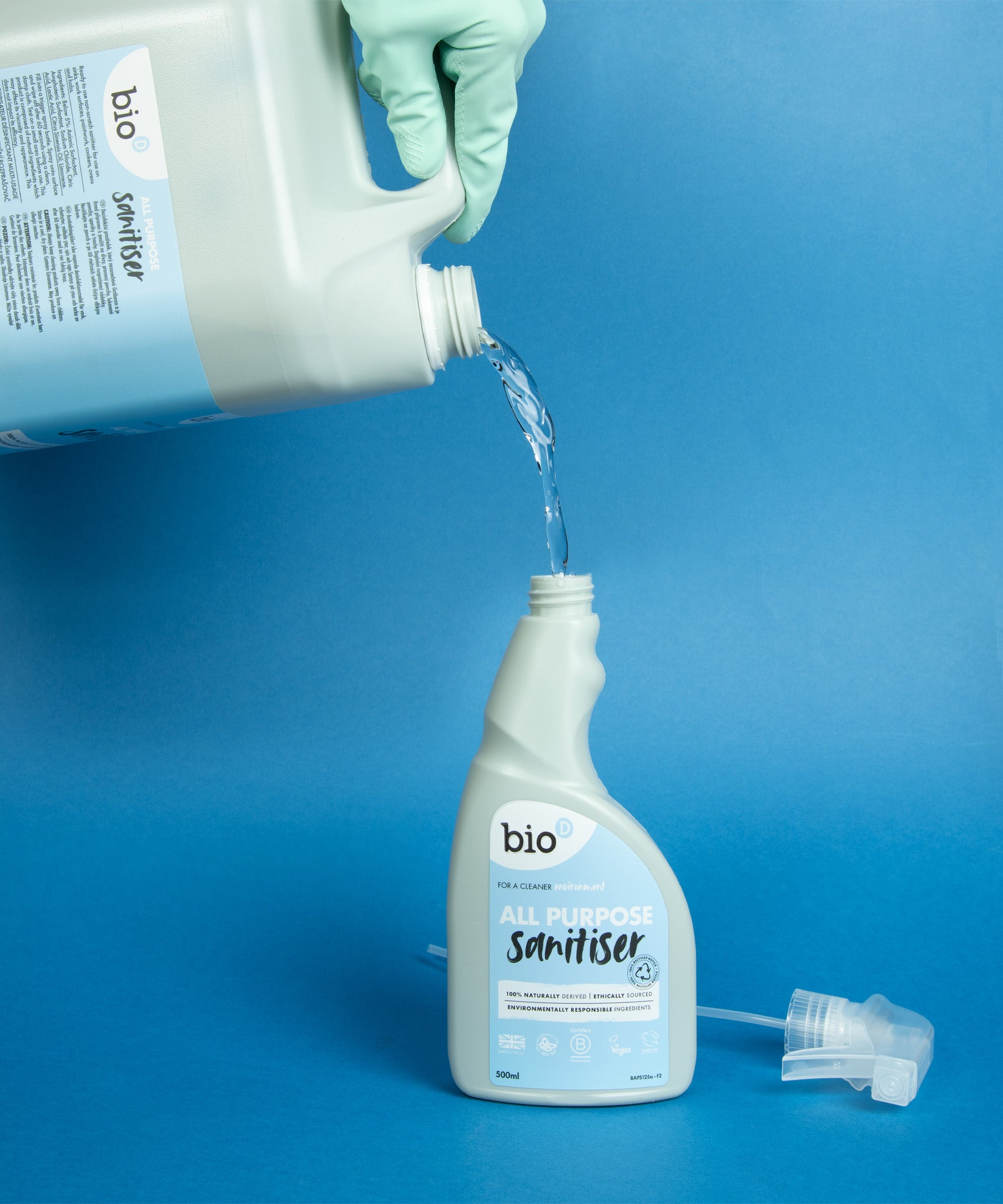 A 5L bottle of Bio-D all purpose sanitiser refill in fragrance free being poured into a 500ml bottle, both available at Babipur.