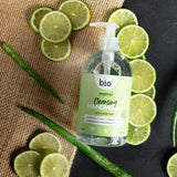 A flatlay image of a 500ml bottle of Bio-D cleansing hand wash  in lime and aloe vera lined up next to slices of lime and aloe. This hand wash is available at Babipur.