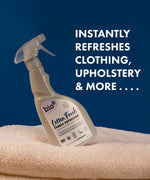 A 500ml spray bottle of Bio-D vegan and cruelty free cotton fresh fabric refresher balancing on a blanket with a feature text on blue background