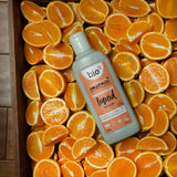 A Bio-D 750ml mandarin washing up liquid bottle in a crate of sliced mandarins. This washing up liquid is available at Babipur 