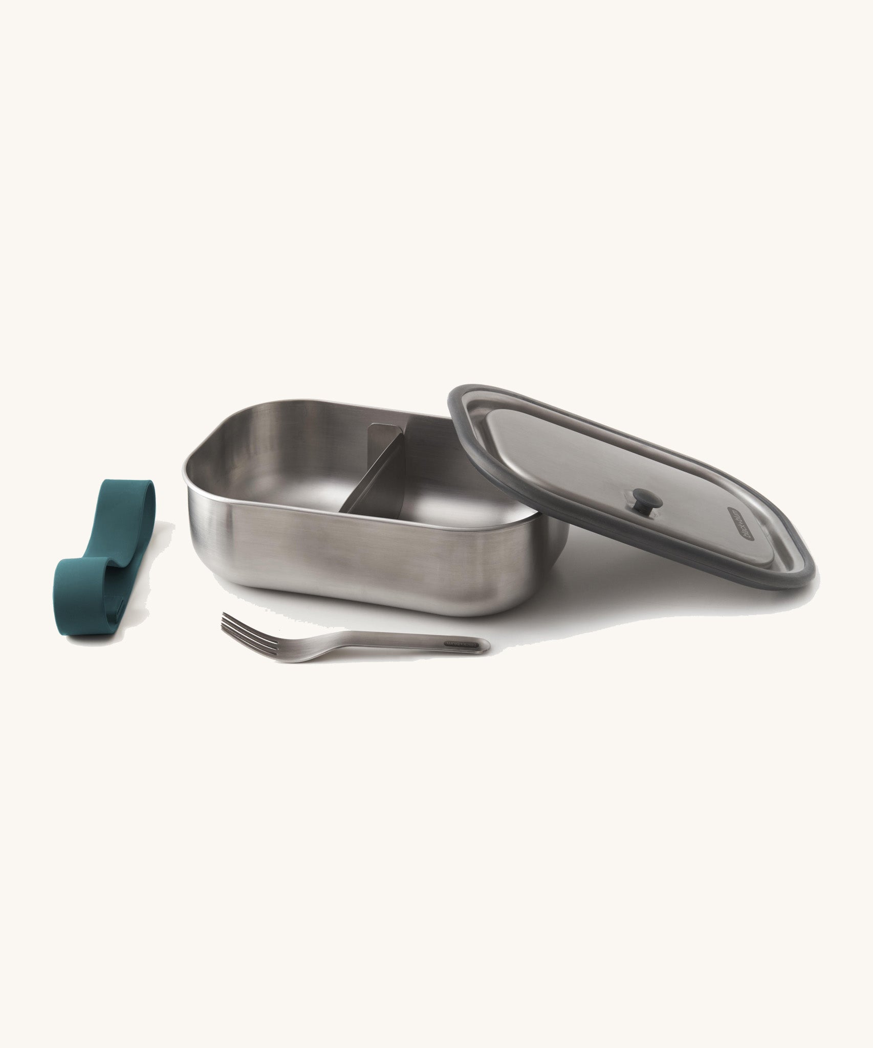Black+Blum Large Leak Proof Stainless Steel Lunch Box with ocean blue coloured strap. The lid is shown resting on the side of the lunchbox with the strap and fork besides it. This lunchbox is part of a wide range of stainless steel lunch box options available here at Babipur. 