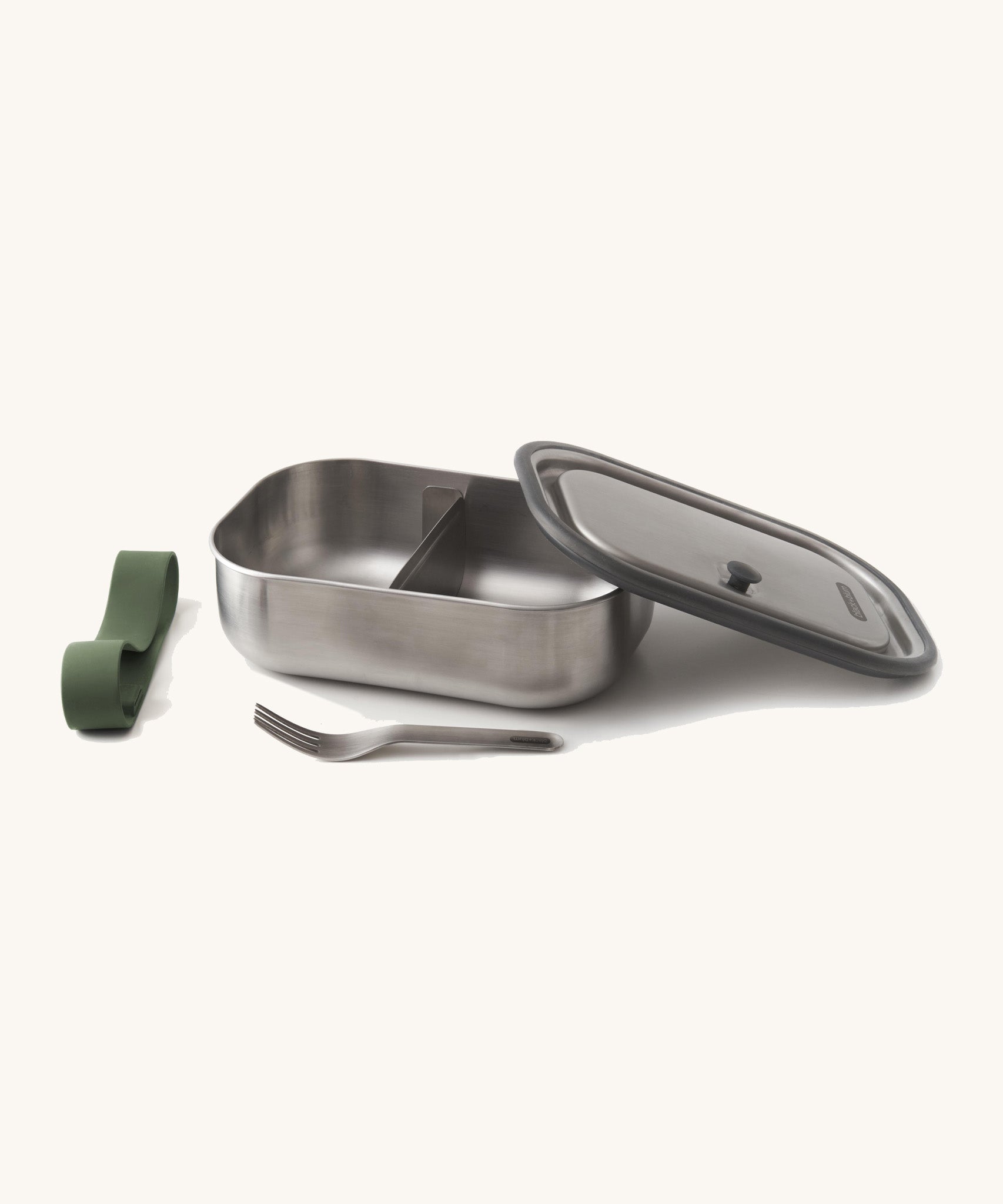 Black+Blum Large Leak Proof Stainless Steel Lunch Box with olive  green coloured strap. The lid is shown resting on the side of the lunchbox with the strap and fork besides it. This lunchbox is part of a wide range of stainless steel lunch box options available here at Babipur. 