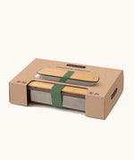 A close up of the brown cardboard packaging holding the Black + Blum stainless steel airtight stainless steel sandwich box 