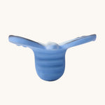A side view of the Oli & Carol Natural Rubber Mini Teether - Blues The Butterfly, showing the texture of the teether, on a cream background