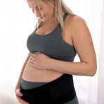 A person wearing the Lola & Lykke Core Relief Pregnancy Support Belt on their pregnancy bump