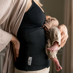 A person holding a baby in their arms, wearing the Lola & Lykke Core Restore Postpartum Belly Band
