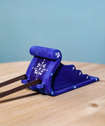 The blue Bumbu Wooden Snow Sleigh Toy is stood on a wooden table with the dark brown wooden reins attached to the front, which are slightly showing in the image
