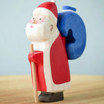 The Bumbu hand crafted and hand painted Santa figure on a light blue and light brown background