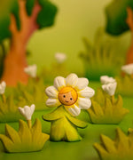 Bumbu wooden daisy flower child figure with standing next to wooden flowers in a playscene