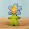 Bumbu handcrafted wooden blue forget me not flower child figure with hand painted facial features standing on a wooden surface