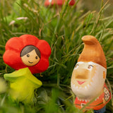 Bumbu wooden red poppy flower child figure next to a wooden gnome figure standing in grass