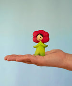 Bumbu wooden red poppy flower child figure standing on a adult hand