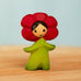 Bumbu handcrafted wooden red poppy flower child figure with hand painted facial features standing on a wooden surface