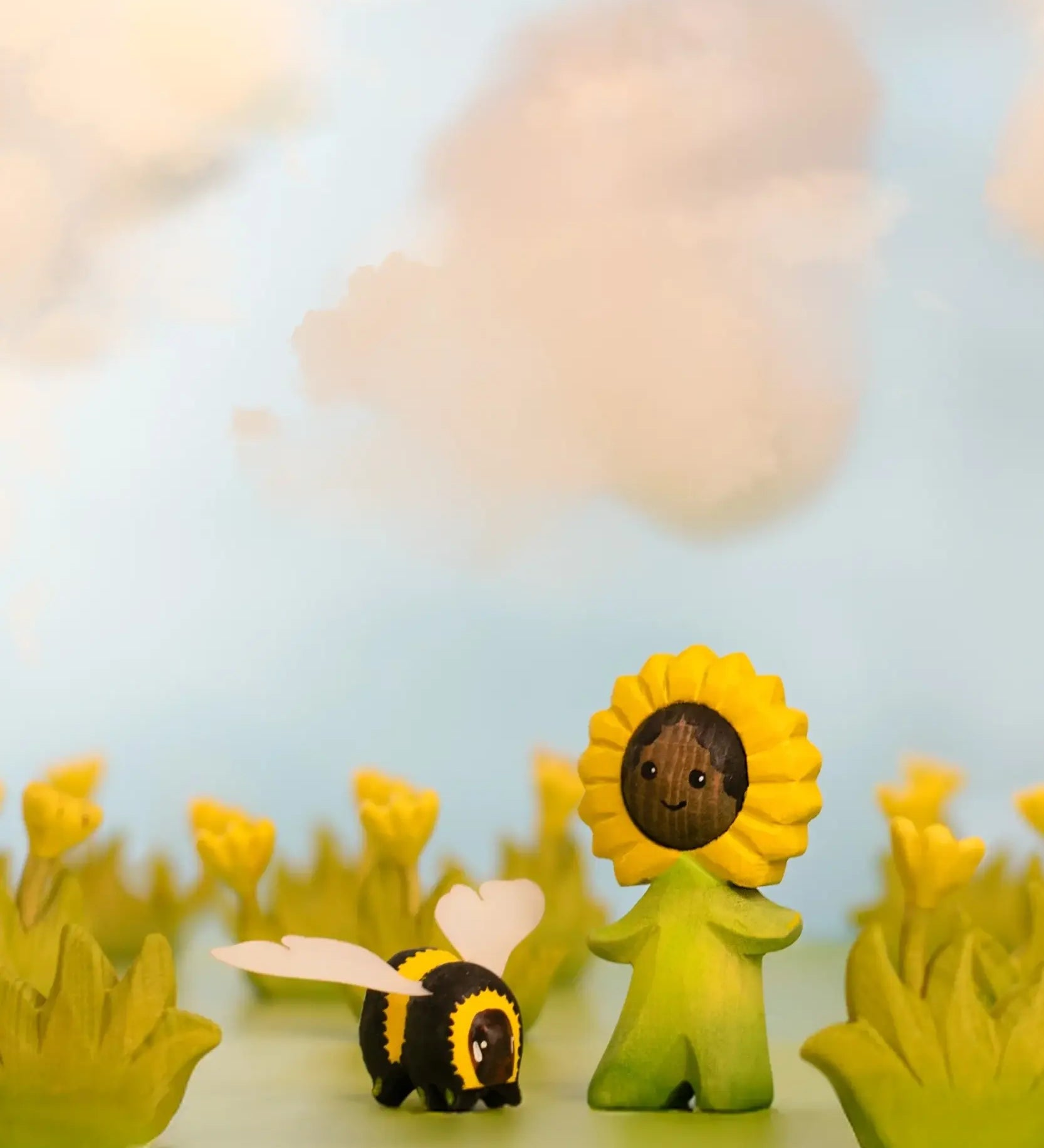 Bumbu wooden sunflower child figure showing hand painted facial features standing next to a wooden bee