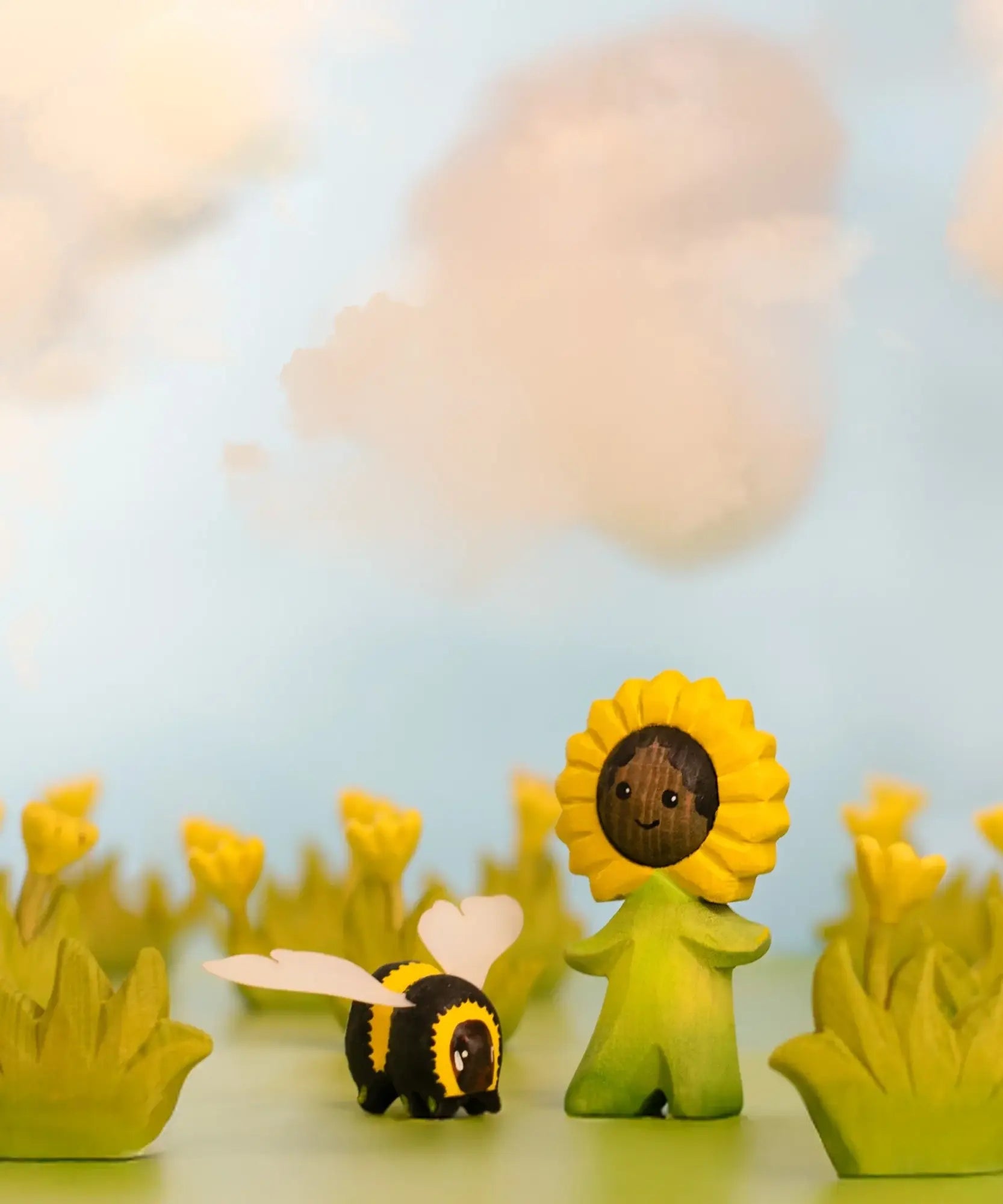Bumbu wooden sunflower child figure showing hand painted facial features standing next to a wooden bee