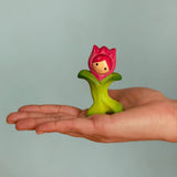 Bumbu wooden pink tulip figure standing on a adult hand