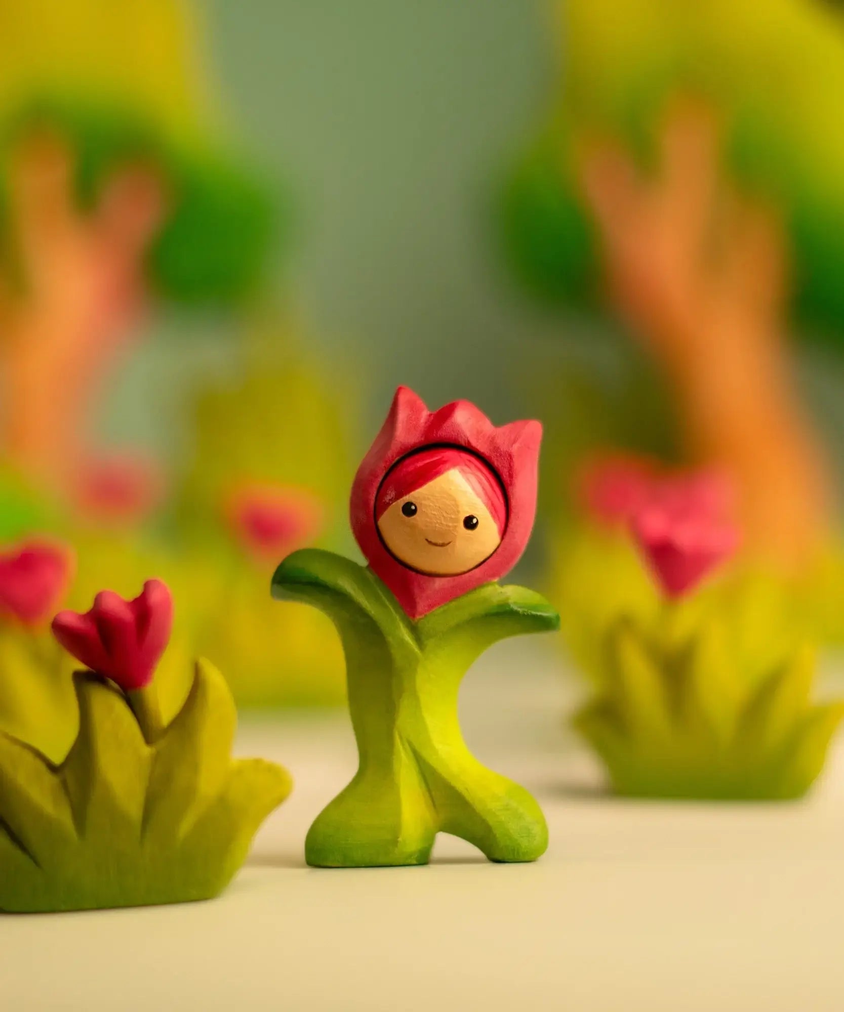 Bumbu wooden pink tulip figure showing hand painted facial features standing next to wooden pink flowers