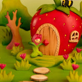 Bumbu wooden pink tulip figure standing next to a wooden strawberry house with a bee on top