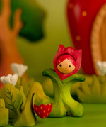 Bumbu wooden pink tulip figure standing next to a wooden strawberry plant