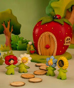 Bumbu wooden flower children standing in front of a wooden strawberry house and trees