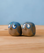 Bumbu hand crafted large wooden love birds figure set standing on a wooden surface.