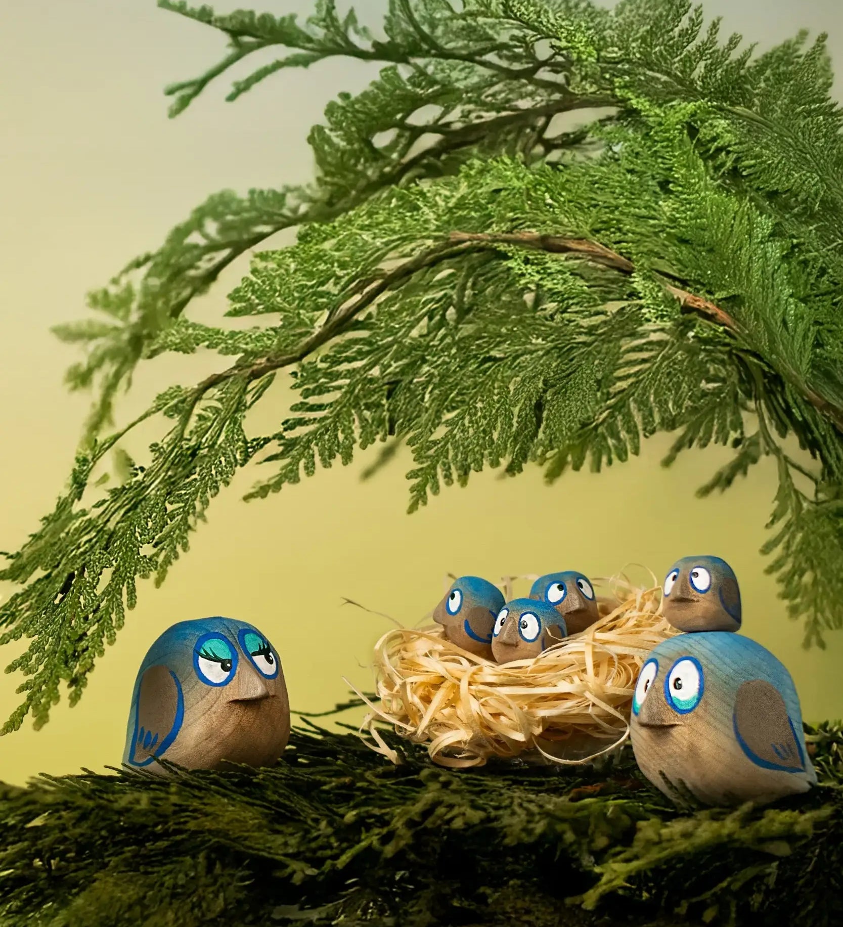 Bumbu hand crafted wooden love birds figures perched on a branch with small birds in a straw nest