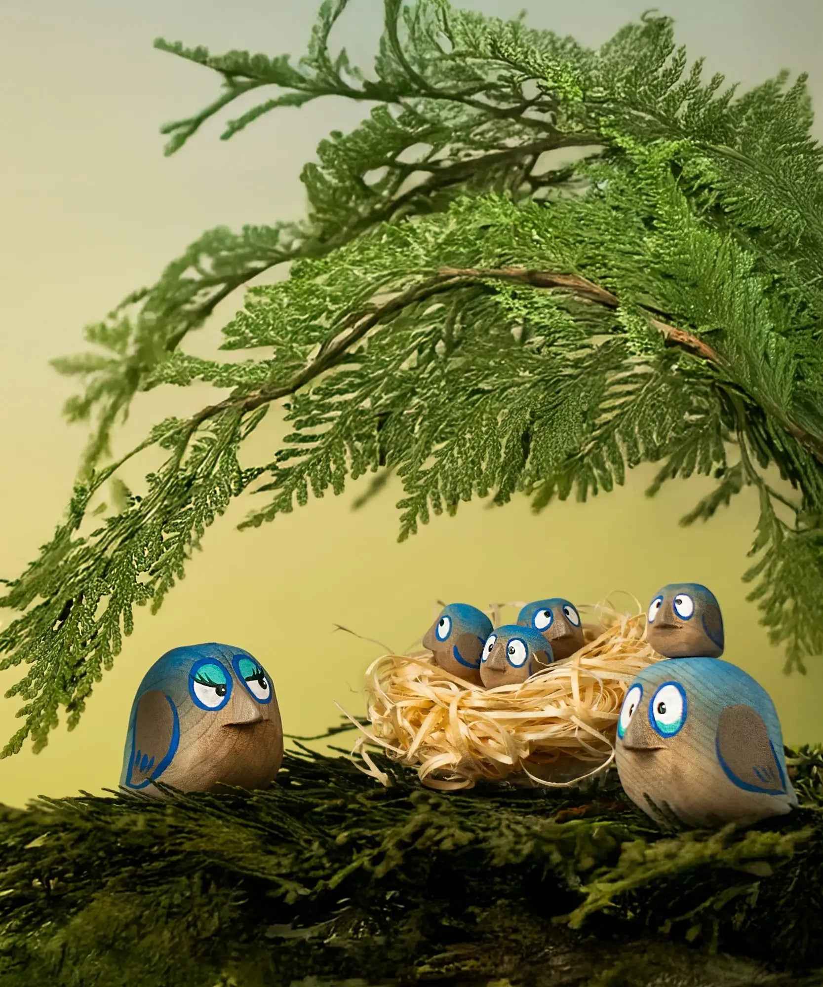 Bumbu hand crafted wooden love birds figures perched on a branch with small birds in a straw nest