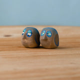 Bumbu hand crafted medium wooden love birds figure set standing on a wooden surface.