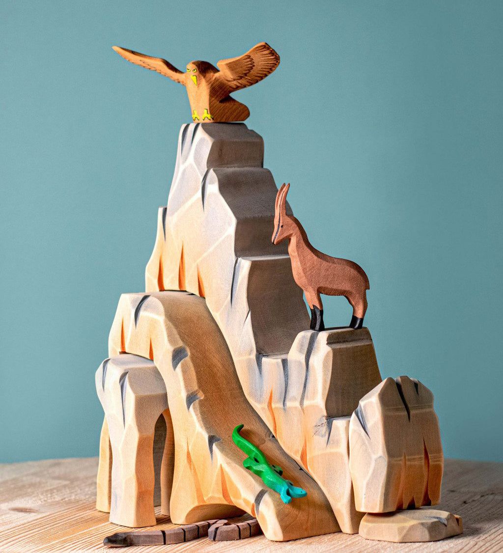 Five-piece Bumbu Mountain Cliffs set made from hand-carved, hand-painted wood. The pieces form tall, rocky cliffs for small-world play. Available at Babipur.