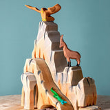 Five-piece Bumbu Mountain Cliffs set made from hand-carved, hand-painted wood. The pieces form tall, rocky cliffs for small-world play. Available at Babipur.