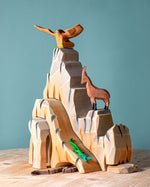 Five-piece Bumbu Mountain Cliffs set made from hand-carved, hand-painted wood. The pieces form tall, rocky cliffs for small-world play. Available at Babipur.