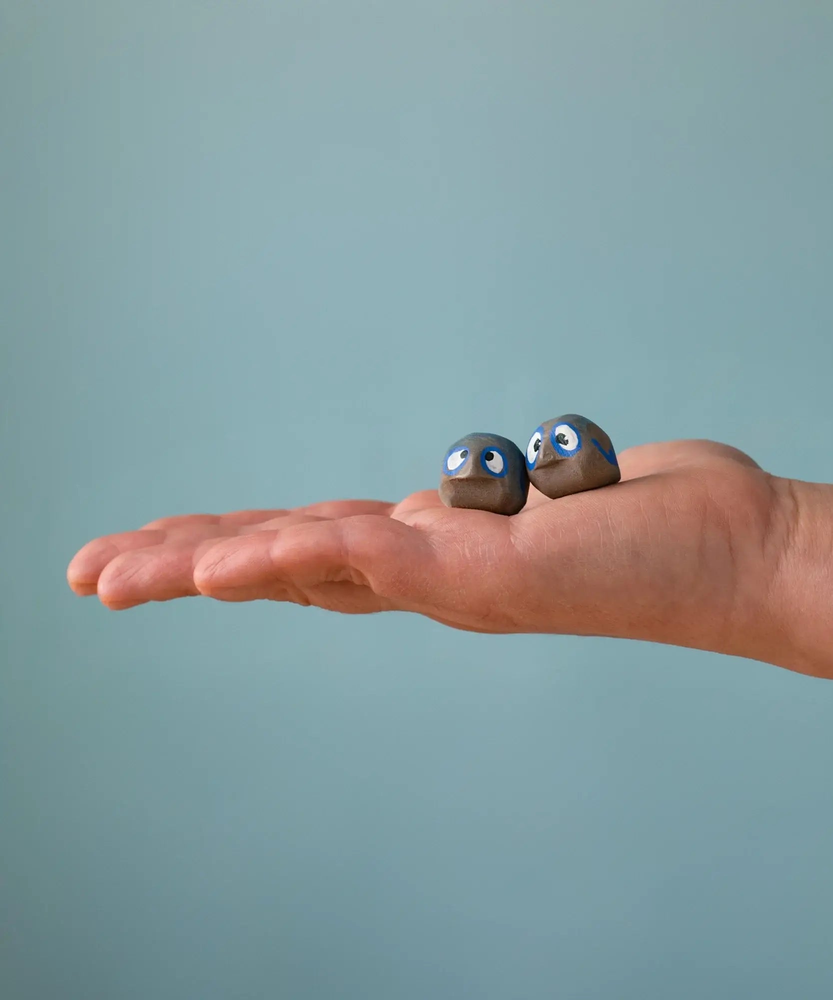 Small Bumbu handcrafted wooden love birds in adult hand