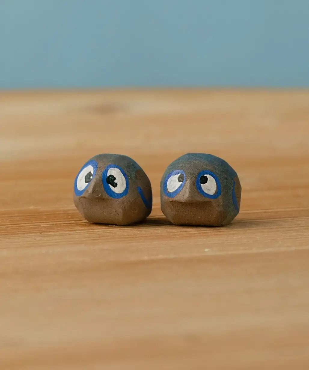 Bumbu hand crafted small wooden love birds figure set standing on a wooden surface.