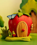 Bumbu handcrafted wooden strawberry house with butterfly on top and strawberry plant standing near