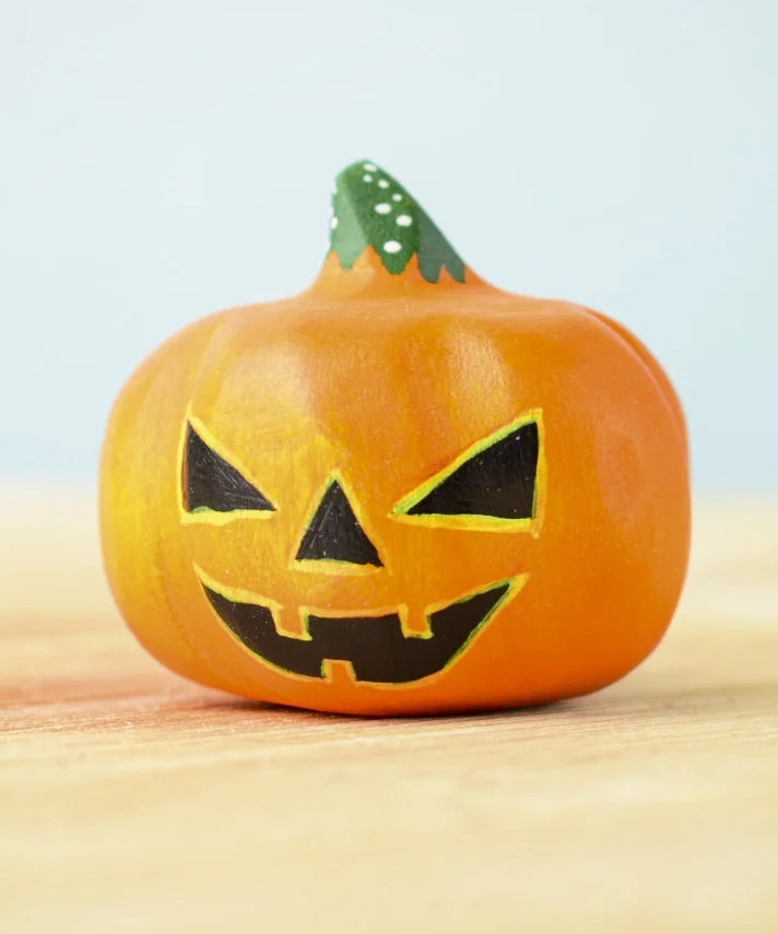 Bumbu Toys Halloween Pumpkin - Medium. The image shows a hand made and hand painted pumpkin figure in orange, with yellow and black facial features and a green and white spotted stem