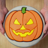 A person holding the Bumbu Toys Halloween Pumpkin Puzzle - Grey, in their hands. The image is a close up view of the pumpkin puzzle from above, showing the different puzzle sections